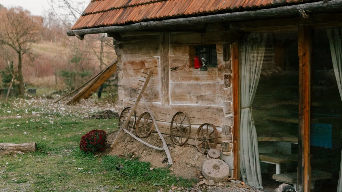 Explore the rustic charm of a Romanian countryside cottage adorned with vintage wheels and earthy tones.